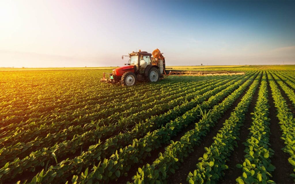 Mountain Plains Agency - Tractor Spraying Soybean Field at Spring